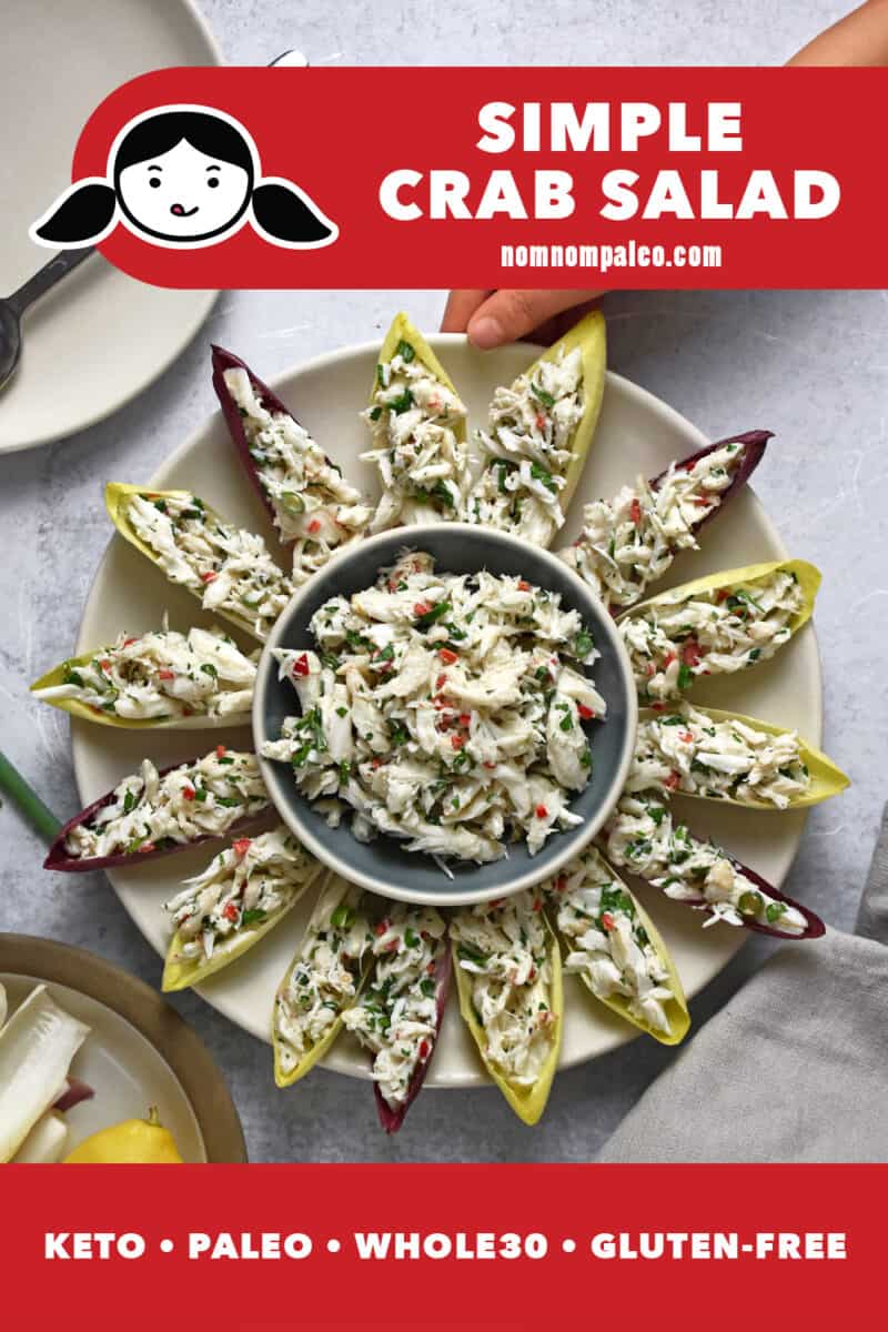 An overhead shot of a round platter filled with endive spears and crab salad.