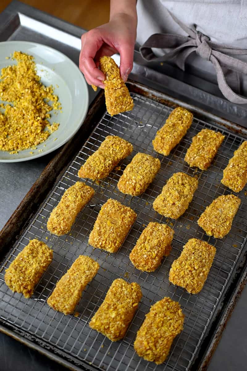 An overhead shot of uncooked battered fish sticks on a wire rack waiting to get cooked in an air fryer