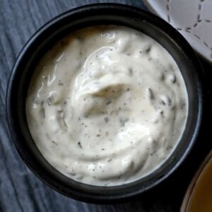 An overhead shot of a black bowl filled with homemade paleo tartar sauce