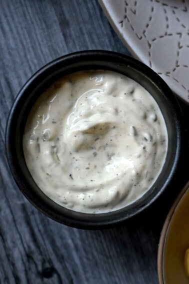 An overhead shot of a black bowl filled with homemade paleo tartar sauce