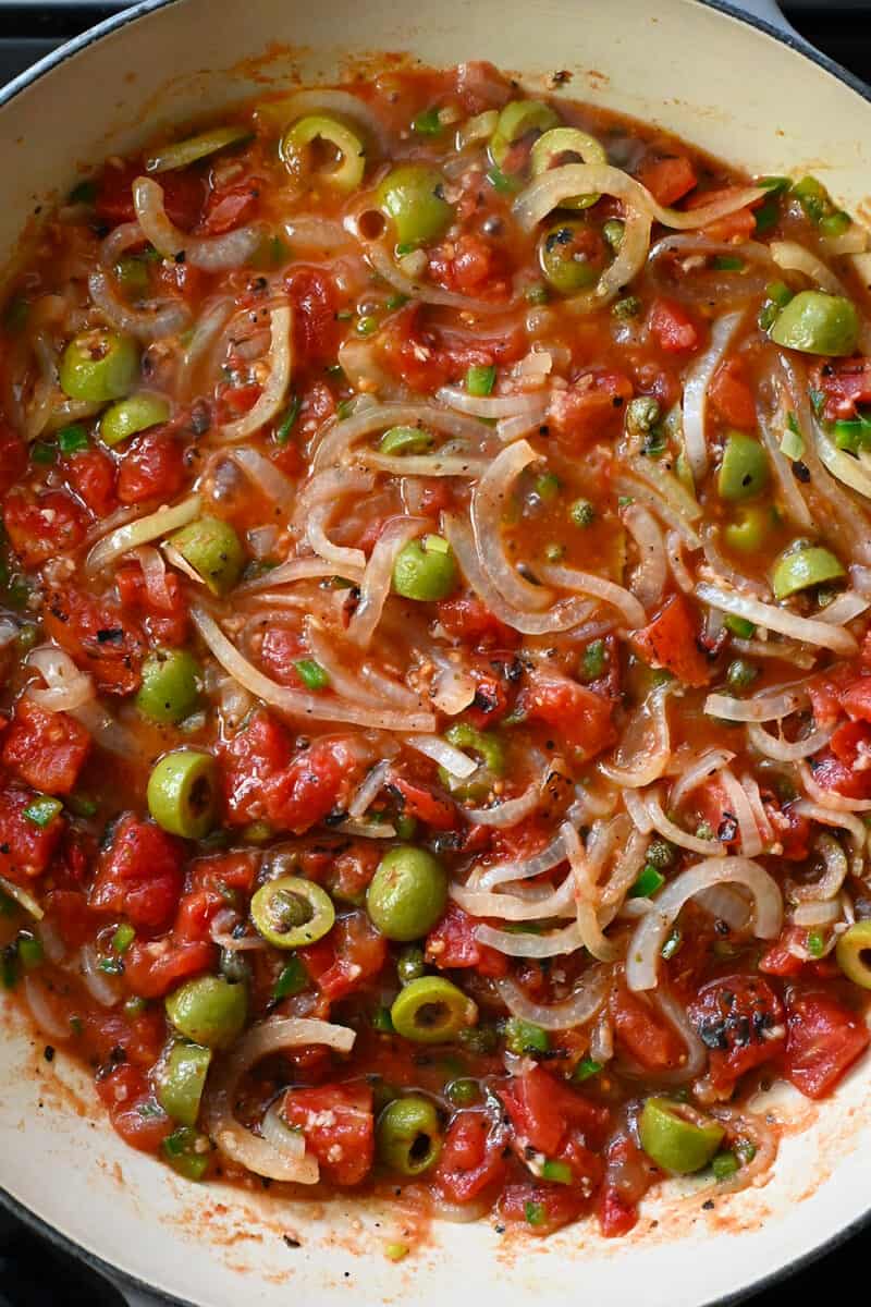 An overhead shot of a skillet filled with simmering Veracruz sauce.