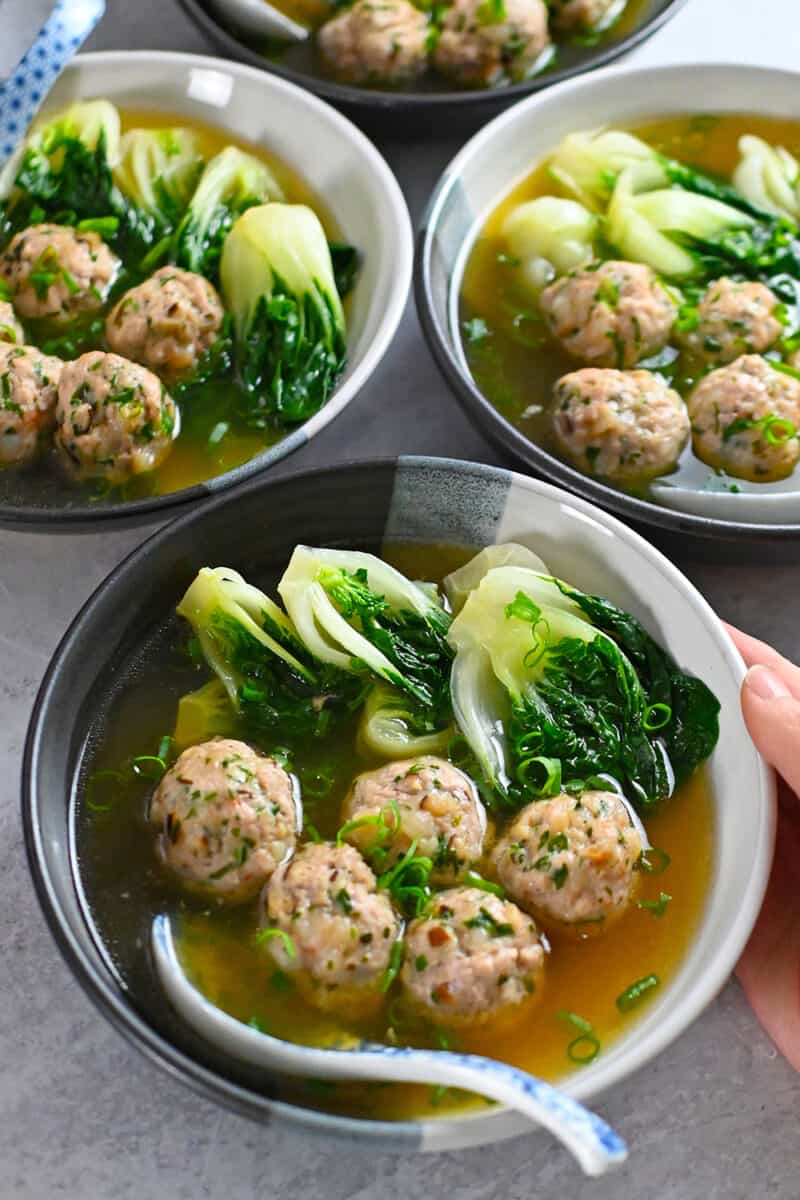 A side view of four bowls of Nom Nom Paleo's wonton soup