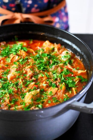 A side view of a gray stockpot filled with paleo and Whole30 cabbage roll soup.