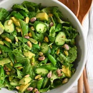 An overhead shot of a big white bowl filled with a vegan and Whole30 chopped salad with sesame ginger dressing.