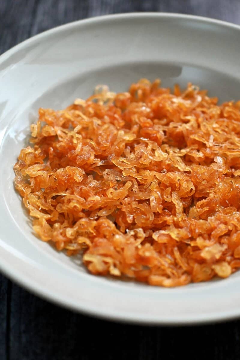 A shallow blue bowl is filled with crispy shallots