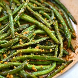 A closeup shot of paleo, Whole30, and gluten free Chinese garlic green beans in a skillet.