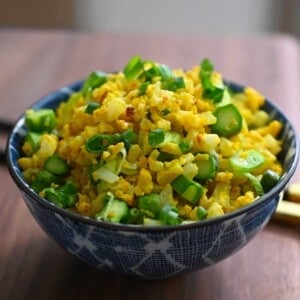 A bowl filled with golden cauliflower fried rice.