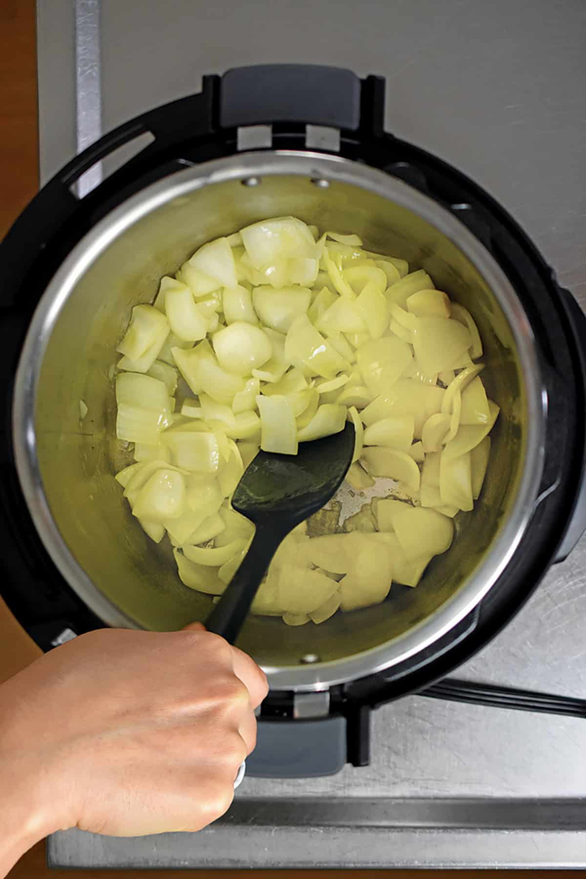 An overhead shot of an open Instant Pot filled with sautéed chopped onions.