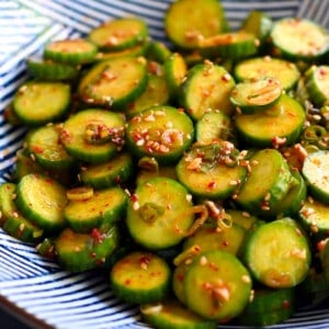 An closeup shot of a blue and white serving bowl with paleo and gluten free Korean cucumber salad.
