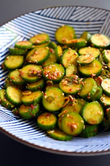 An closeup shot of a blue and white serving bowl with paleo and gluten free Korean cucumber salad.