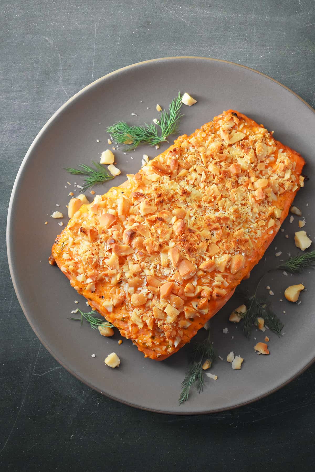 An overhead shot of macadamia crusted sriracha ranch salmon on a beige plate.