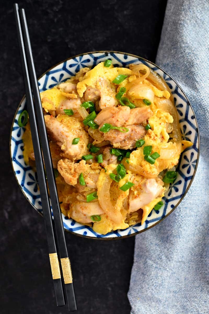 An overhead shot of a bowl filled with paleo and low carb oyakodon with a pair of black chopsticks on the bowl.