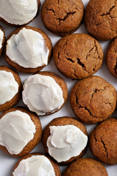 An overhead shot of a plate filled with paleo and gluten free pumpkin cookies, some frosted and some with no frosting on top.