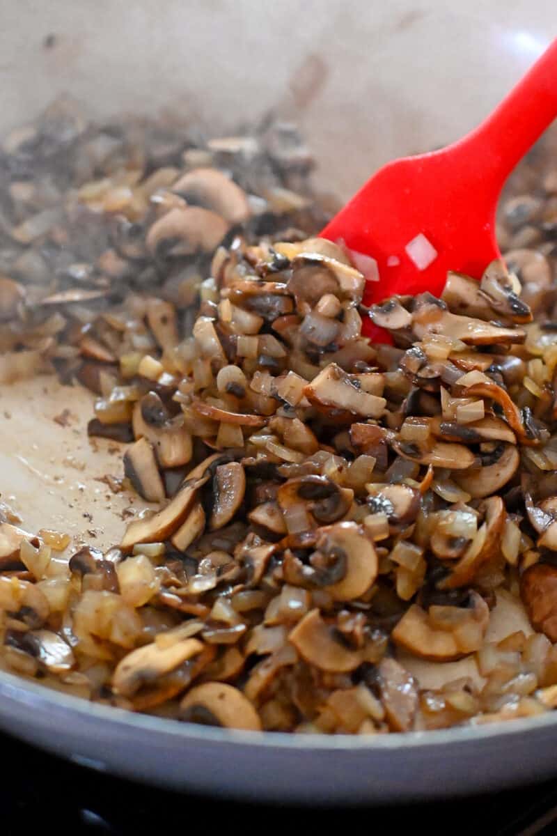 Sliced mushrooms and onions cooked in a skillet until the liquid has evaporated from the pan.