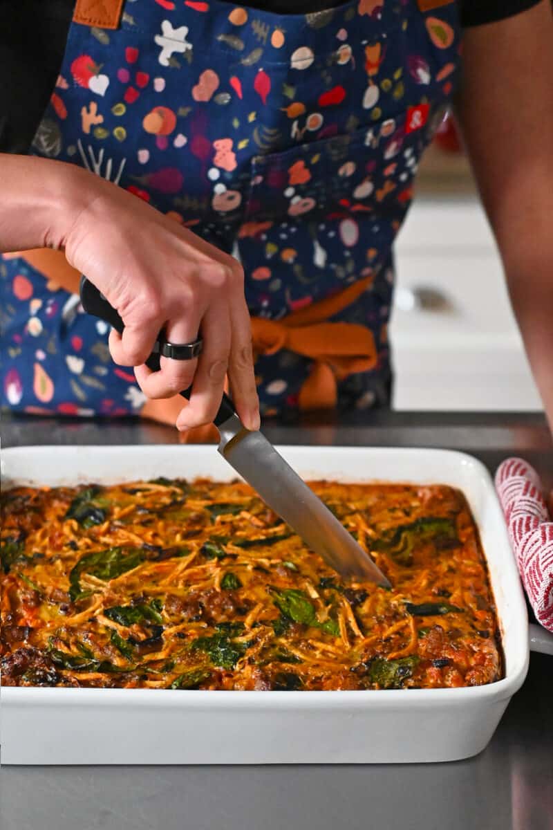 Slicing a paleo and Whole30 sausage breakfast casserole to serve.