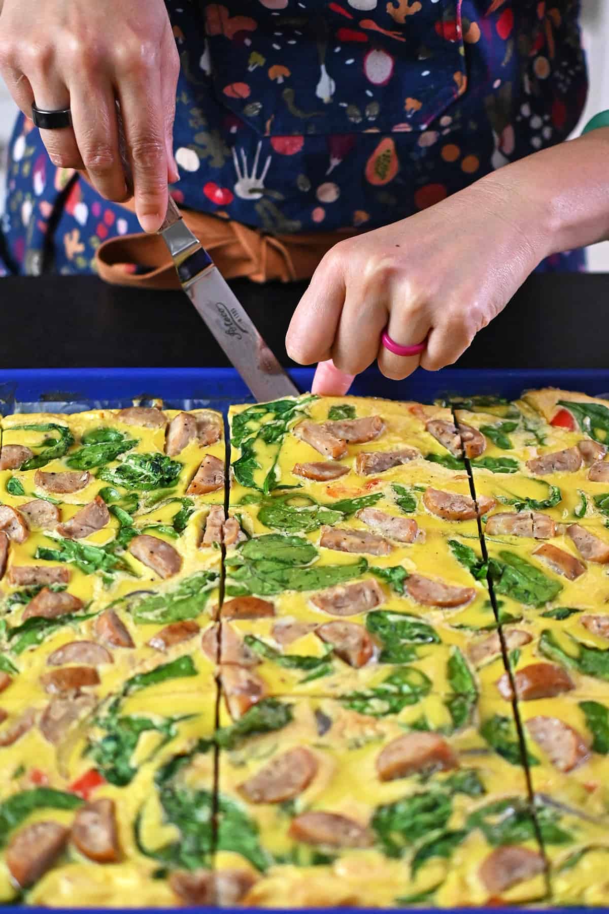 Using a small offset spatula to remove a slice of sheet pan eggs.