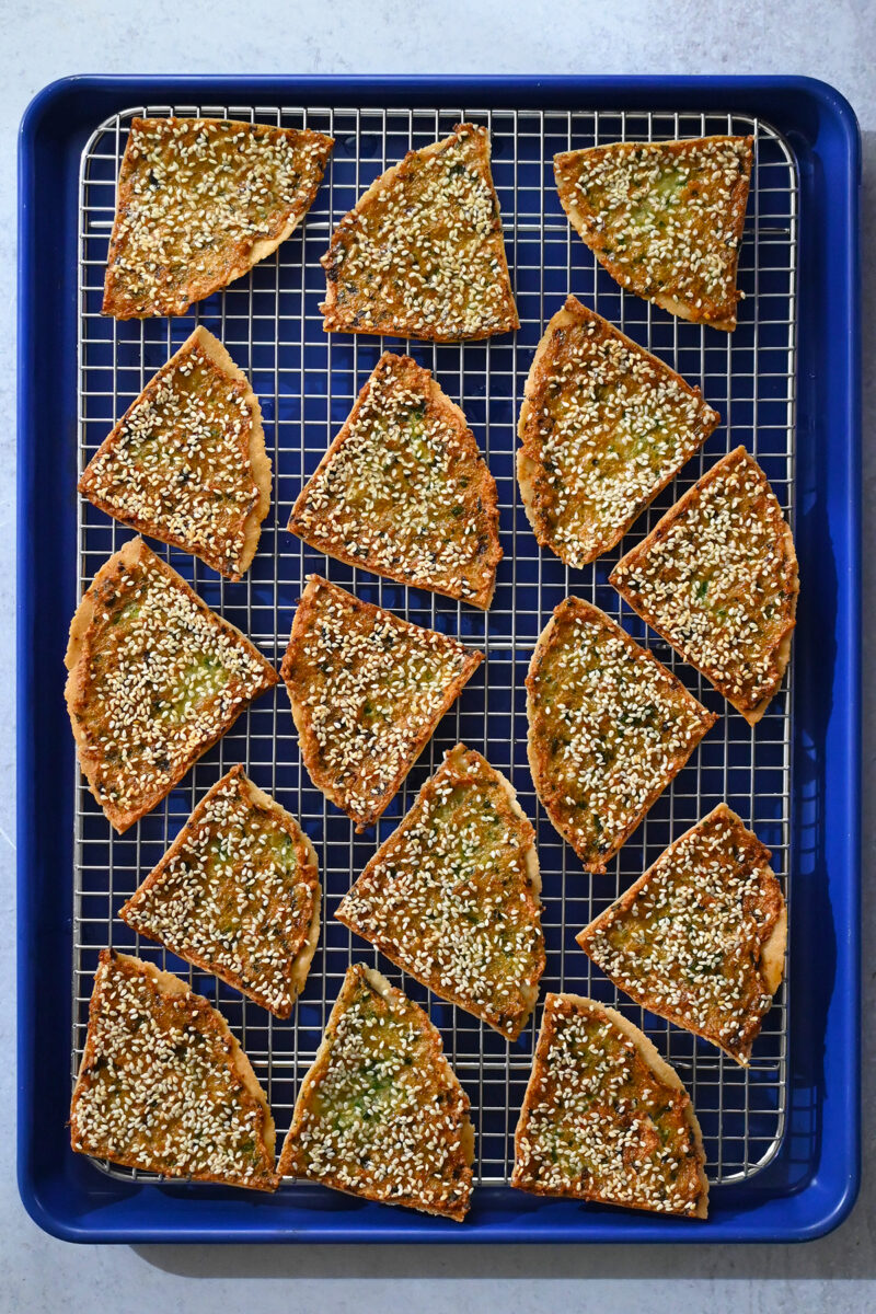 An overhead shot of golden brown shrimp toast on a cooling rack.