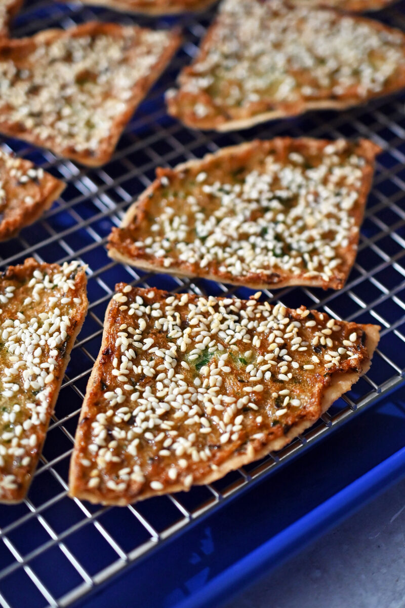 A closeup of golden brown paleo and gluten free shrimp toast cooling on a wire rack.