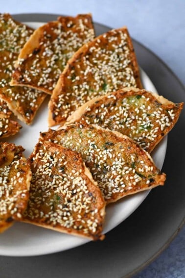 A plate with golden brown wedges of paleo shrimp toast arranged in a circle.
