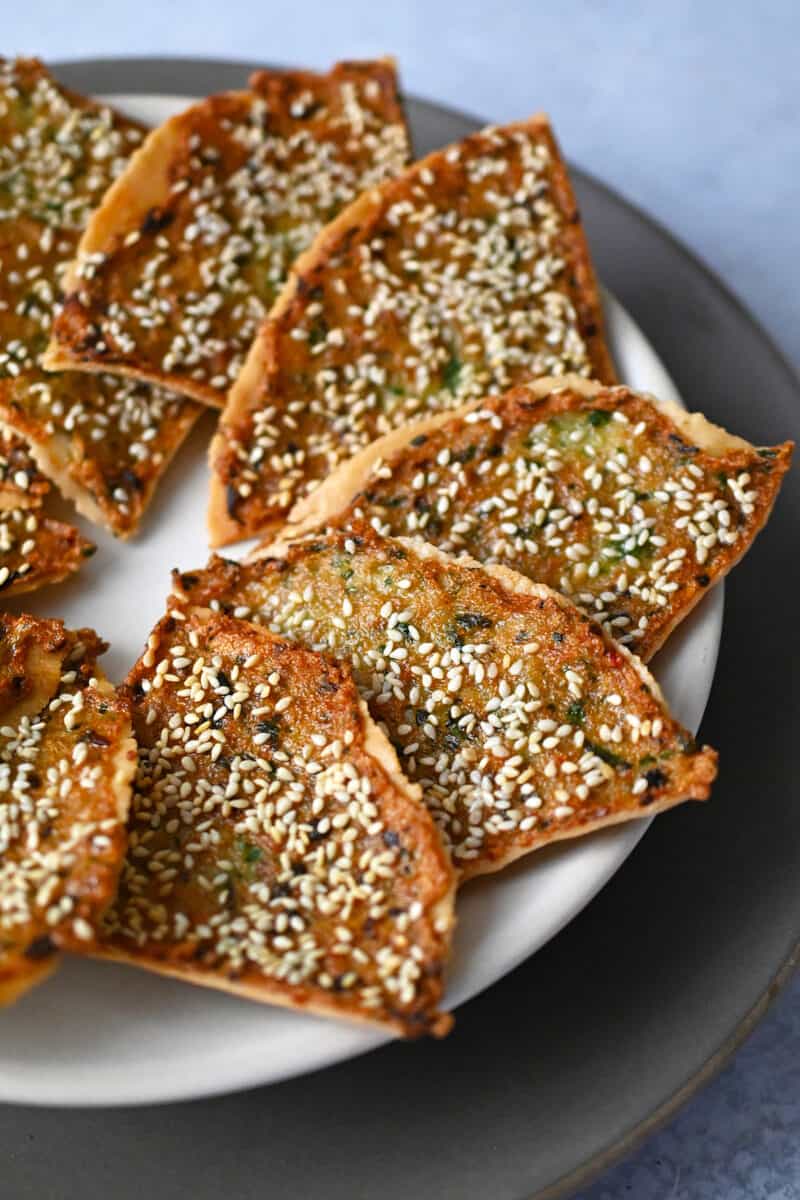 A plate with golden brown wedges of paleo shrimp toast arranged in a circle.