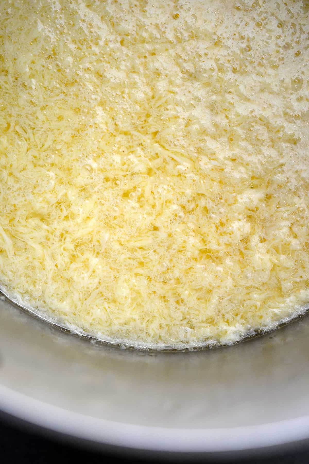 A closeup of egg drop soup in a saucepan.