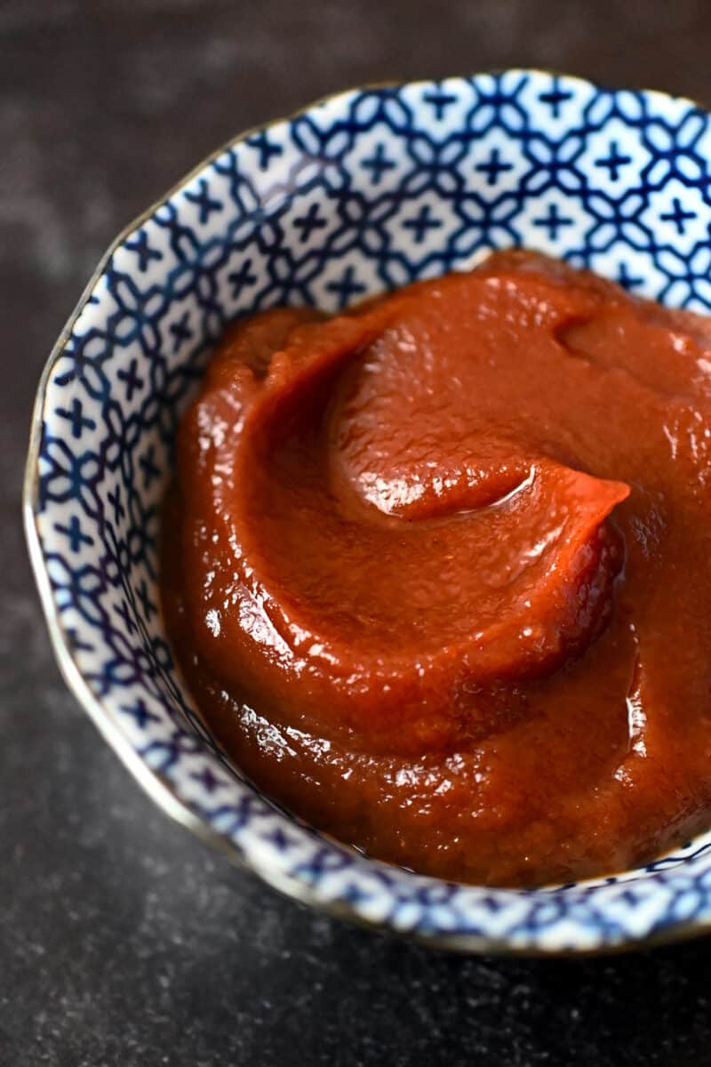 A closeup of homemade Tonkatsu Sauce in a blue and white shallow bowl.