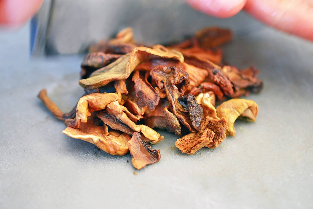 Rehydrated dried porcini mushrooms on a gray cutting board.