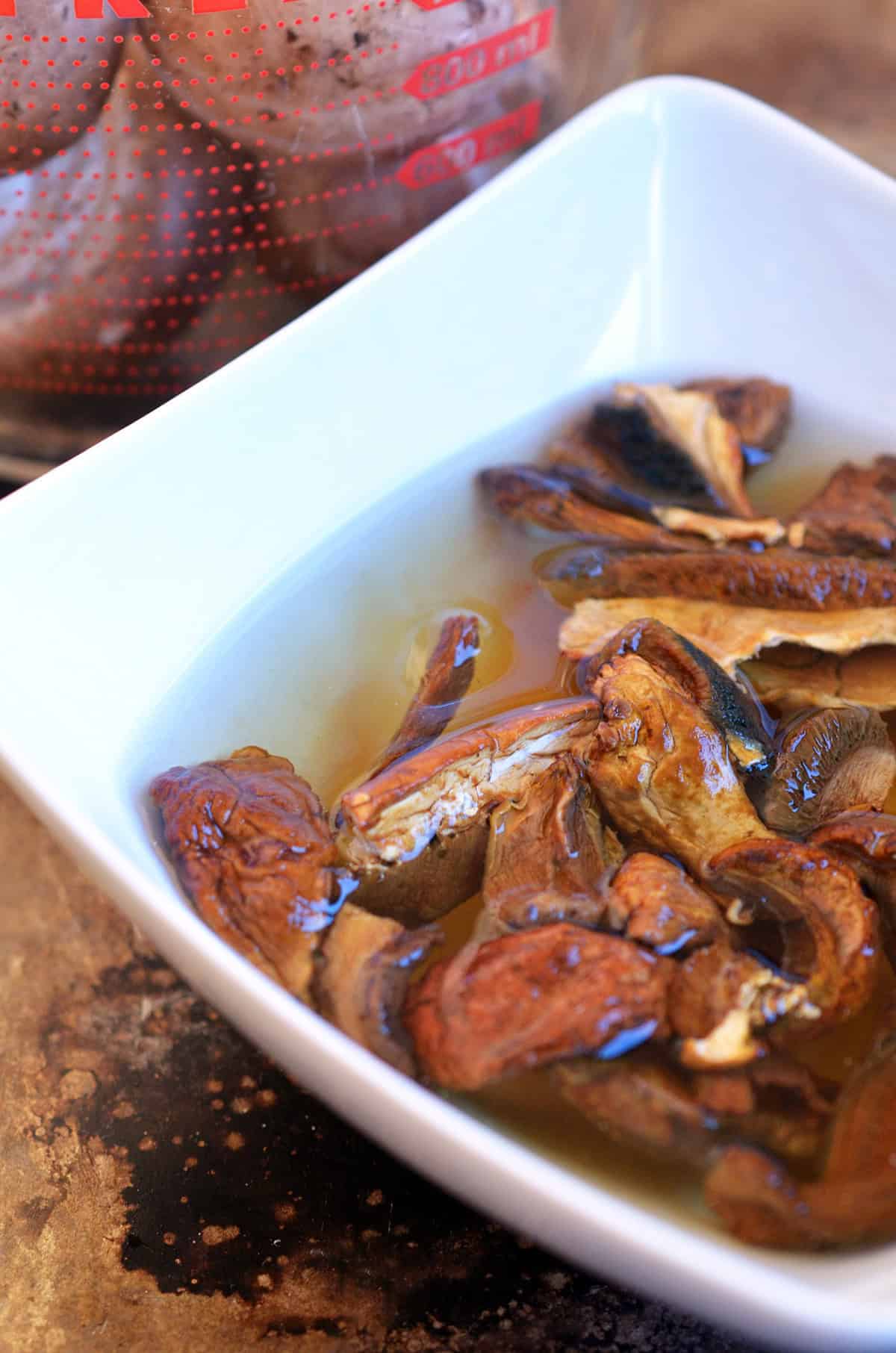 Dried porcini mushrooms soaking in water in a white bowl to make a gluten free gravy.