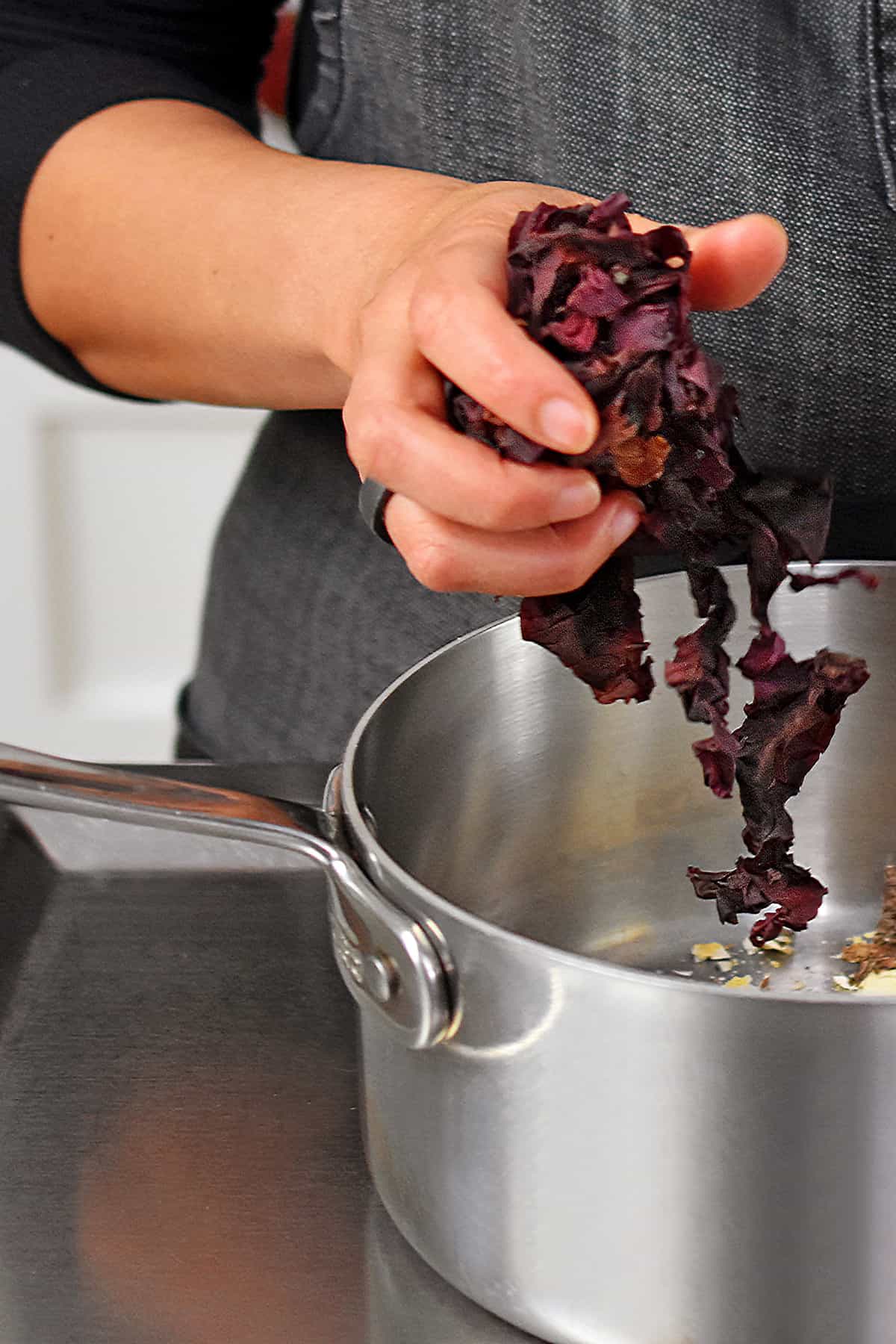 Adding a handful of dried dulse into a small saucepan to make vegan fish sauce.