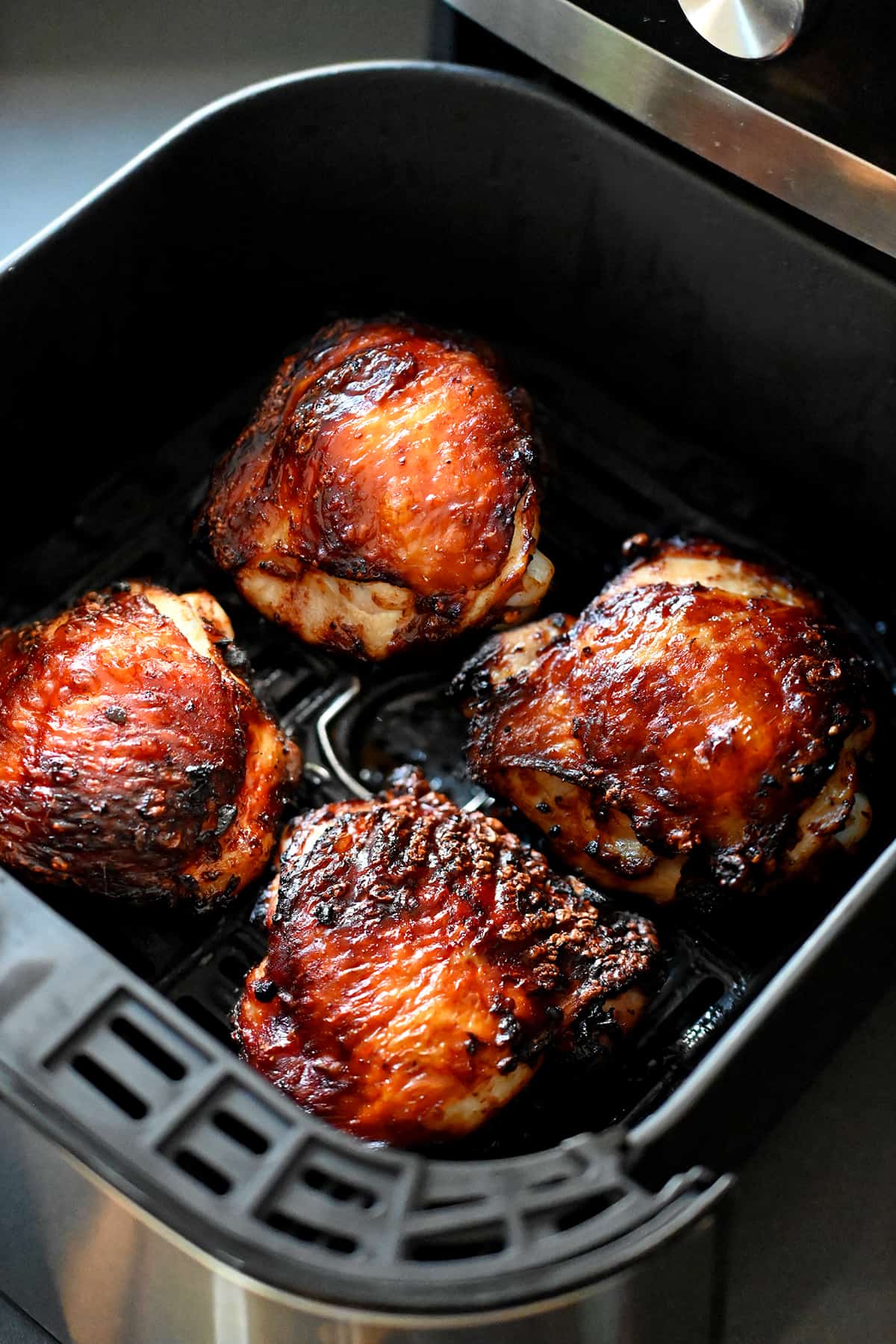 An open air fryer with golden brown paleo Vietnamese Lemongrass Chicken inside.