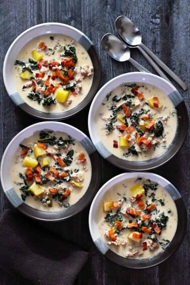 An overhead shot of four bowls of dairy-free Zuppa Toscana.