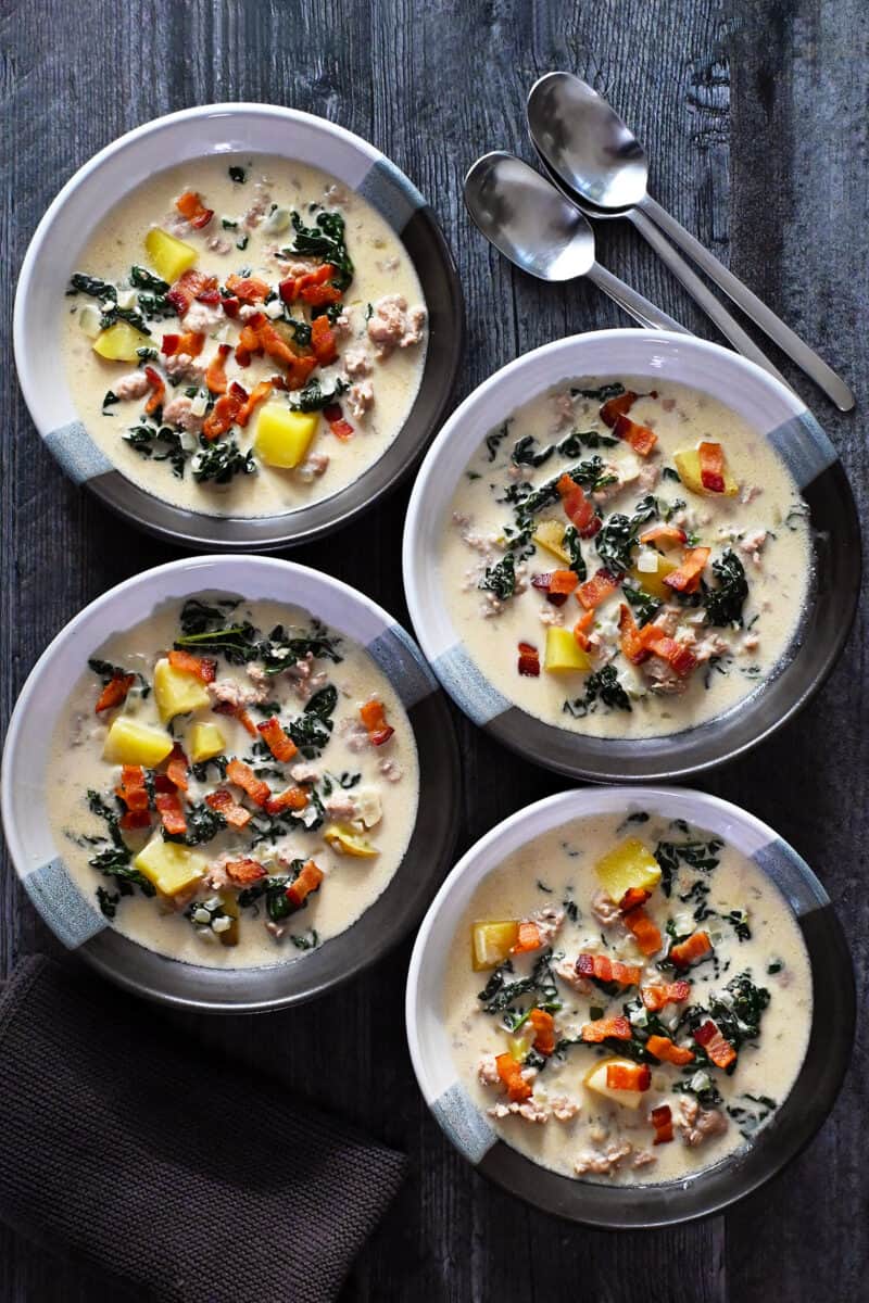An overhead shot of four bowls of dairy-free Zuppa Toscana.