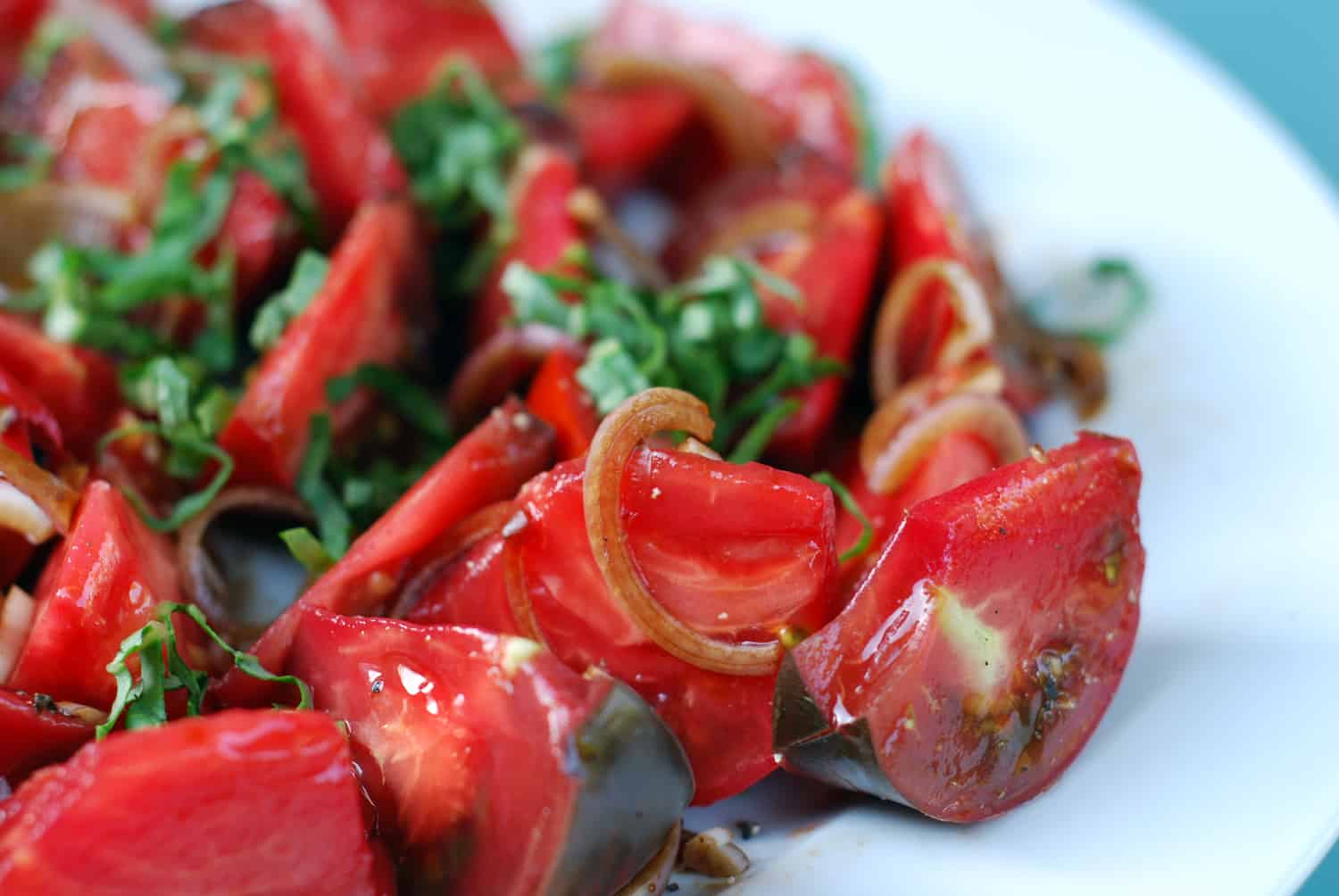 A platter of Tomato and Basil salad on a white plate.