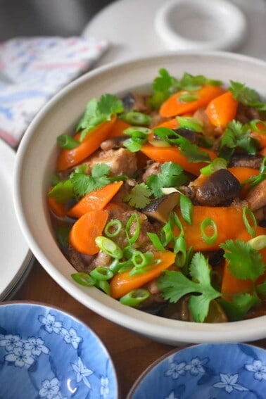 A side shot of Instant Pot Vietnamese Pork Stew in a round serving dish on a dining table.