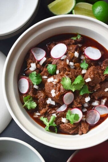Overhead shot of Instant Pot Cowboy Chili topped with sliced radishes, cilantro, and diced onions.