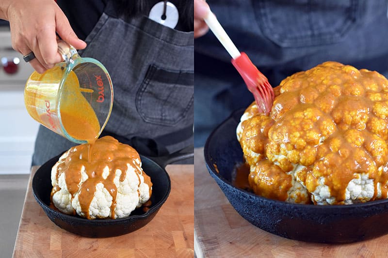 Someone pouring Nom Nom Paleo Tandoori marinade to make whole roasted cauliflower.