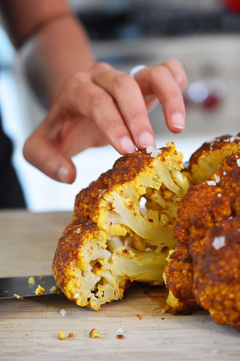 Someone slicing into Tandoori Whole Roasted Cauliflower