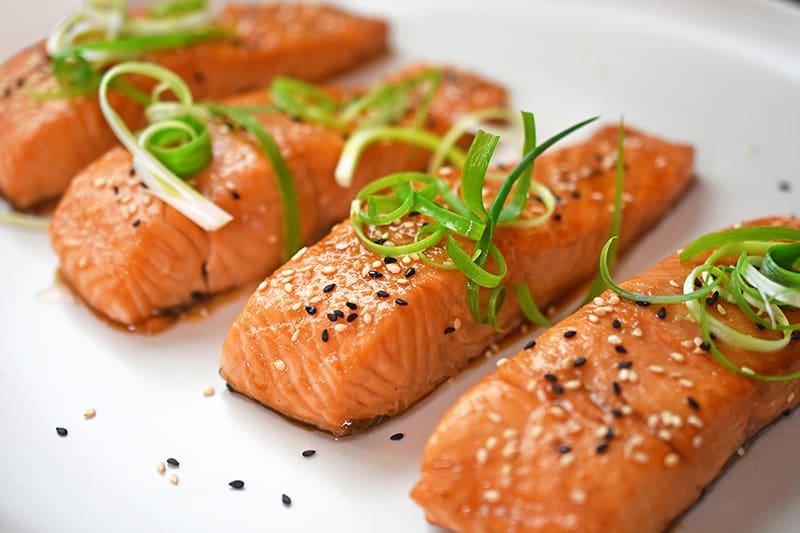 Easy gluten-free teriyaki salmon topped with scallions and toasted sesame seeds.