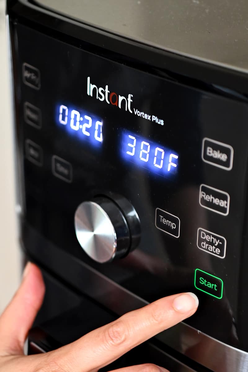A person is programming an Instant Pot air fryer to air fry at 380F for 20 minutes.