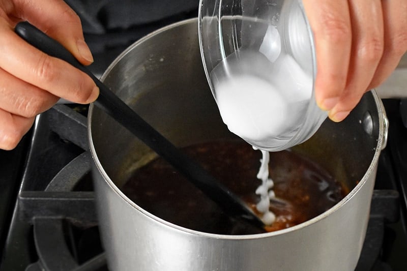 Pouring arrowroot slurry into the Whole30 and paleo asian sauce for sticky wings.