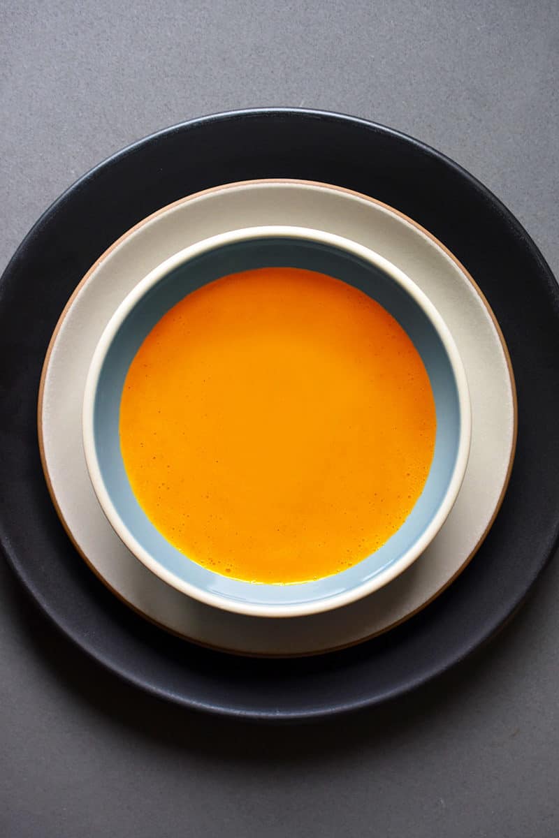 An overhead shot of Carrot Cardamom soup in a serving bowl.