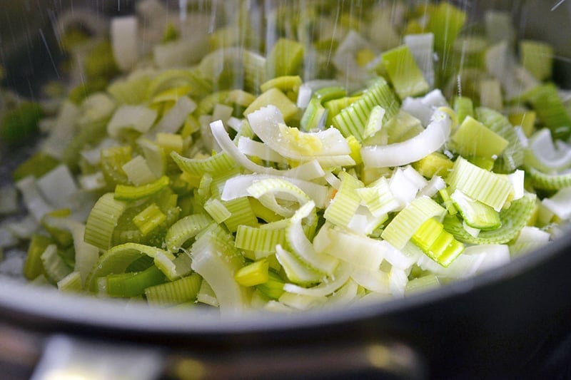 Sprinkling salt on sliced leeks for Carrot Cardamom Soup