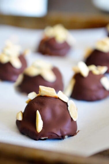 A closeup of a tray of Chunky Monkey Ice Cream Bon Bons, a paleo and vegan dessert with banana ice cream topped with a chocolate shell and toasted almonds.