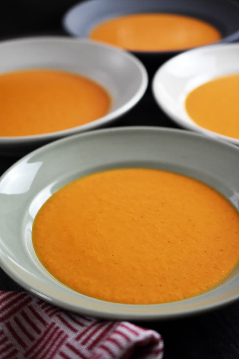 Four bowls of cream of tomato soup.