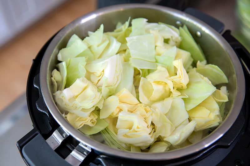 An overhead shot of an Instant Pot filed with cabbage to make low carb Ethiopian vegetable stew.