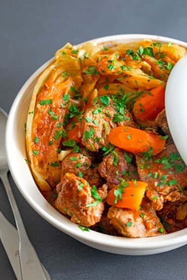 An overhead shot of a large bowl filled with Slow Cooker Pork and Cabbage stew, a paleo and Whole30-friendly healthy supper.