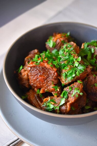 An overhead shot of a bowl of Instant Pot Magic Short Ribs in a dark blue bowl ready to serve