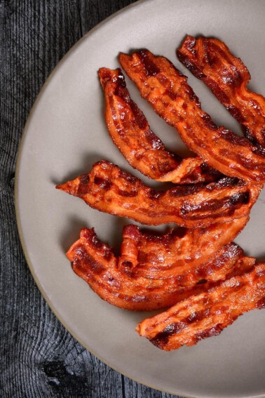An overhead shot of a brown plate covered with crispy microwave bacon.