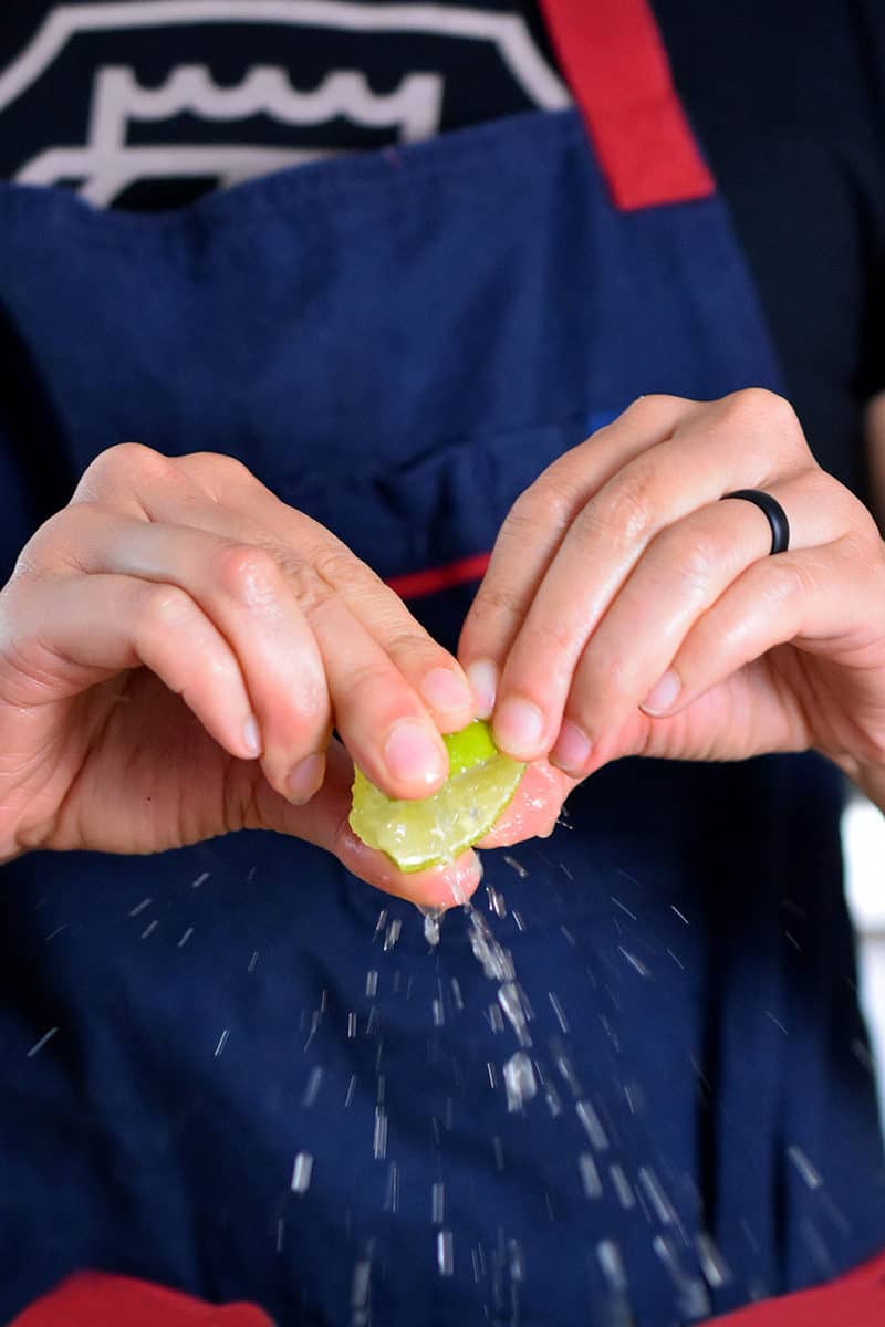 Someone squeezing fresh lime juice.