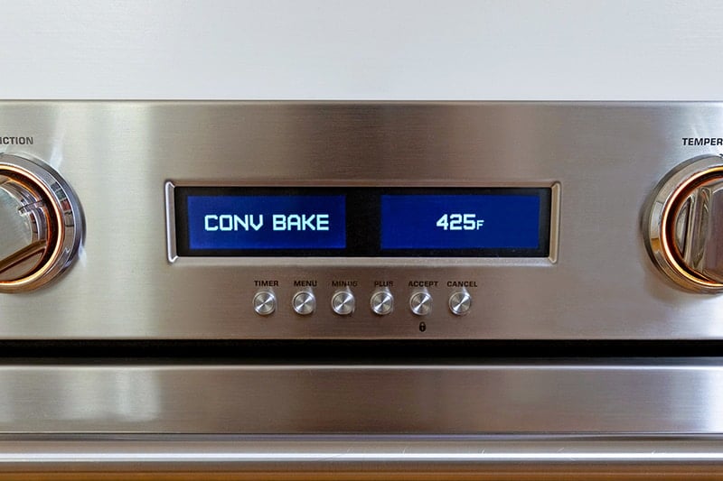 A closeup of an wall oven display that says CONV BAKE 425°F